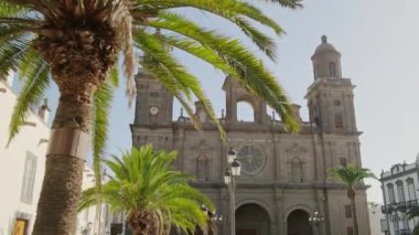 Sabit çekim, Santa Ana de Canarias Katedrali 'nin Gran Canaria' da bir palmiye ağacının arkasından çekildiğini gösteriyor. Las Palmas 'taki Saint Ana meydanındaki tarihi katedral. Kanarya adaları seyahat yeridir.