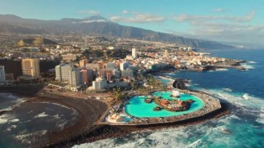 Tenerife, İspanya ile Puerto de la Cruz şehir manzarası. Purto de la Cruz kasabası Tenerife, Kanarya Adaları 'nda gündoğumunda arka planda Teide volkanı vardı. Yörünge atışı