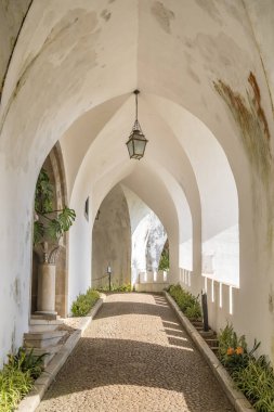 Sintra kasabası Lizbon 'daki ünlü Pena Sarayı' nın içinde beyaz koridor ve fenerle güzel bir kemer yolu.