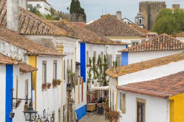 Historic streets of the medieval Obidos castle in Portugal. Old portuguese buildings with tiled roofs of the medieval fortified Obidos town, Portugal.