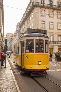 Lizbon, Portekiz - 29 Mart 2022: Lizbon, Portekiz 'deki eski sarı tramvay. Geleneksel tarihi tramvayı yolcuları taşıyan Lisboa şehrinden sokak sahnesi
