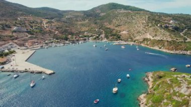 Yunanistan 'ın İyon Denizi' ndeki Zakynthos adasındaki Agios Nikolaos balıkçı köyü. Zante 'deki küçük Yunan Agios Nikolaos limanında turkuvaz suyu bulunan güzel körfezdeki teknelerin hava manzarası. Yörünge atışı