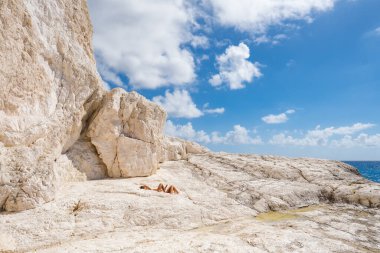 Tanımlanamayan çift, Yunanistan 'ın İyon Denizi' ndeki Zakynthos adasının kireçtaşı kayalık sahillerinde güneşleniyor. Zante adasının vahşi kıyıları. Yunan bayramı, yaz tatili konsepti