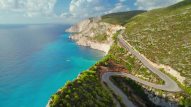 Yunanistan 'ın Zakynthos adasındaki yüksek uçurumlar ve turkuaz deniz suyuyla dolu güzel bir sahil yolunun havadan manzarası. Yunanistan 'daki Zante adasının varış noktası. İnsansız hava aracı görüntüleri