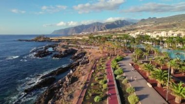 İspanya 'nın Kanarya Adaları, Tenerife, Alcala kasabasındaki Atlantik Okyanusu kıyısındaki şehir parkının havadan görüntüsü. Gün batımında Tenerife 'deki güzel gezinti güvertesinin hava aracı görüntüsü.