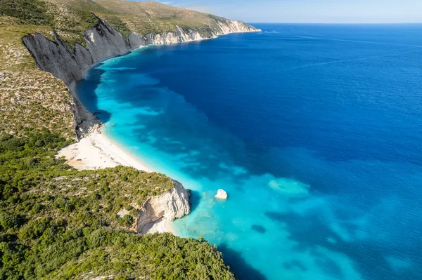 Remote Fteri beach on the Kefalonia island, Ionian sea, Greece. Aerial view of the beautiful coast with white sand beach, high limestone cliffs and amazing turquoise sea water, Cephalonia Greek island