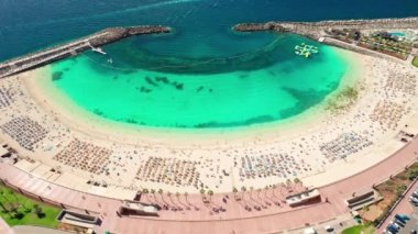 Playa de Amadores sahilinin havadan görünüşü, Gran Canaria, Kanarya Adaları, İspanya. Kanarya adalarında lüks tatil yerleri. Turkuaz deniz suyu plajı manzarası aşağı. Yörünge atışı