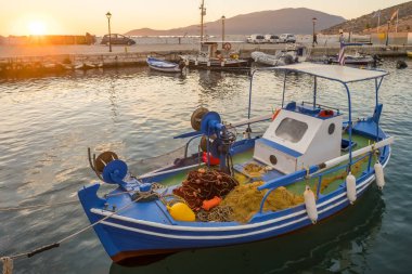 Günbatımında Agia Effimia limanında demirlemiş ağlarla geleneksel Yunan balıkçı teknesi, Kefalonia, İyon denizi, Yunanistan.
