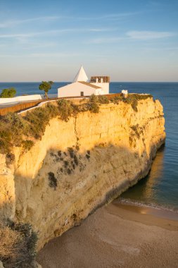Atlantik Okyanusu 'ndaki günbatımı manzarası güzel kilise Sinyora de Nossa, Algarve bölgesi kıyı şeridi, Güney Portekiz. Portekiz 'de Nossa Kilisesi Senyora da Rocha