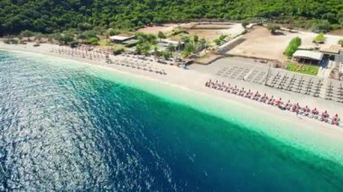 Yunanistan 'ın Kefalonia adasındaki Antisamos plajında kristal berraklığında masmavi bir su. Kefalonia Adası, İyon Adası, Yunanistan 'da güneşli yataklı ve şemsiyeli cennet manzarası. 
