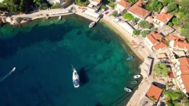 İyon Denizi, Yunanistan Kioni Körfezi, Ithaka Adası 'nın havadan görünüşü. Yunanistan 'ın Ithaka adasındaki Kioni balıkçı köyü. Turkuaz deniz suyuyla güzel bir sahil. Drone yörünge atışı