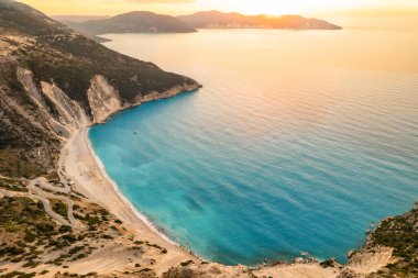 Yunanistan 'ın İyon Denizi' ndeki Kefalonia adasındaki ünlü Myrtos plajının günbatımı manzarası. Popüler Myrtos plajının en iyi manzarası.