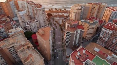 İspanya 'nın Malaga şehrindeki güzel sahil manzarası. Kumsal, konut binaları ve Malaga 'da güneş doğarken sahil yolu. İspanyol seyahat yeri. Eğik atış gösteriliyor