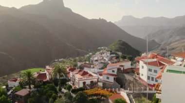 Roque Nublo 'nun arka planda, Gran Canaria, Kanarya Adaları' ndaki Tejeda köyünün günbatımı manzarası, İspanya. Hala çekiliyor, yavaşça uzaklaşıyor.