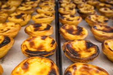 Freshly baked crunchy traditional Portuguese dessert Pastle de Nata with custard on the counter. Portuguese custard tarts Pasteis de nata. Shallow depth of field