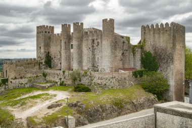 Portekiz 'in bulutlu bir gününde ortaçağ tahkim edilmiş bir köy olan Obidos Kalesi. Obidos 'taki ortaçağ şatosunun ön görüntüsü