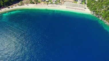 Yunanistan 'ın Kefalonia adasındaki Antisamos plajında kristal berraklığında masmavi bir su. Yunanistan 'ın İyon Adası' ndaki Kefalonia Adası 'nda güneşli yataklı cennet sahili manzarası. yörünge atışı