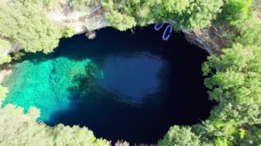 Yunanistan 'ın Kefalonia adasındaki ünlü Melissani Gölü. Yunanistan 'ın Kefalonya adasındaki Karavomylos köyündeki Melissani Mağara Gölü' nün havadan görünüşü. İnsansız hava aracı görüntülerini büyüt