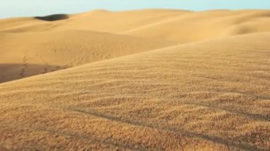 Çöldeki kum tepelerinin yakın görüntüsü, rüzgarın kumlara işlediği karmaşık desenler. Çöl manzarasının ham ve doğal güzelliği. Sabit çekim yavaş çekim
