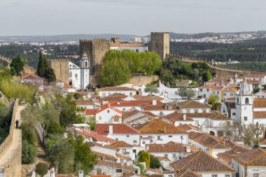 Obidos Medieval Town, Portugal. Aerial view of the historic walled town of Obidos, near Peniche, Portugal. Naroow streets and historic buildings of the Medieval fortress in Obidos.