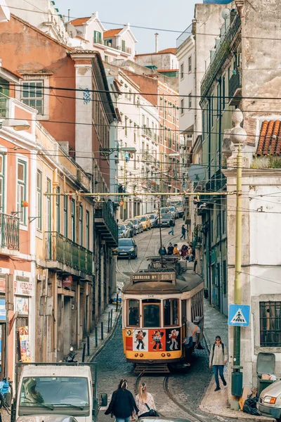 葡萄牙里斯本 2022年3月29日 葡萄牙里斯本狭窄街道上的旧黄色电车 利斯波市的街景 传统的历史缆车载着乘客 — 图库照片
