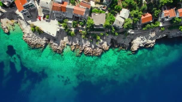 从空中俯瞰克罗地亚的普里莫斯特镇海岸 亚得里亚海美丽的海水 有着令人难以置信的蓝色和绿松石色 洛基海岸 有传统的克罗地亚人住宅 — 图库视频影像