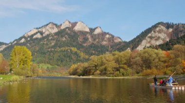 Trzy Korony, Polonya - 24 Ekim 2022: Dunajec Nehri üzerinde ahşap sallarda geleneksel rafting. Rafting, Pieniny Ulusal Parkı 'nda popüler bir turistik merkezdir. Sonbaharda üç taç dağı