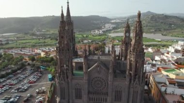 Aerial view of the Parroquia de San Juan Bautista de Arucas church in Arucas town, Gran Canaria, Canary Islands, Spain. Flying over the Neo-Gothic cathedral in Arucas. Drone orbit shot.