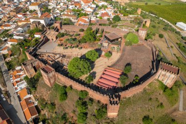 Portekiz 'in Algarve bölgesindeki ünlü ortaçağ şatosu ve katedrali olan Silves kasabasının hava manzarası. Silves tarihi kalesinin üzerinde uçuyor.