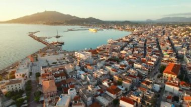 Yunanistan 'ın Zante adasındaki Zakynthos kasabasının hava manzarası. Zakynthos şehrinin güneş doğarken çekilmiş insansız hava aracı görüntüleri. Yörünge çekimi, Yunanistan 'ın tatil beldesi sahnesini yakaladı.