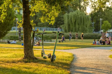 Wroclaw, Polonya - 10 Haziran 2022: Yazın Wroclaw 'daki halk parkına bırakılan Lime adlı araç paylaşım şirketinin elektrikli scooterları, eksperi veya e-scooterı