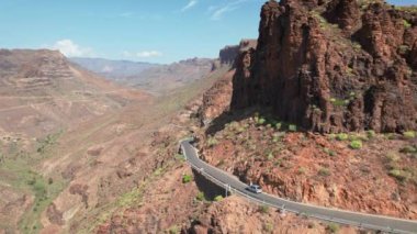 Gran Kanarya adasının güzel manzarası. İspanya 'nın Kanarya Adaları' ndaki Gran Kanarya Kanaryası 'nın büyüleyici kuru kayalık arazisiyle çevrili Barranco de Fataga Kanyonu' ndaki kıvrımlı bir dağ yolunun hava manzarası..