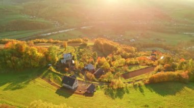 Polonya 'da sonbahar sezonu boyunca Polonya' nın daha küçük kesimlerinde gün batımında bir dağ köyünün güzel kırsal manzarası. Dağın kırsal kesimindeki çarpıcı sonbahar renkleri