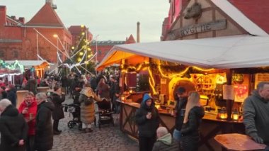 Berlin, Almanya - 7 Aralık 2022: Berlin 'de geleneksel Noel pazarı. Berlin şehir merkezindeki Kulturbrauerei merkezinde kışın Noel pazarını ziyaret eden kimliği belirsiz kişiler.