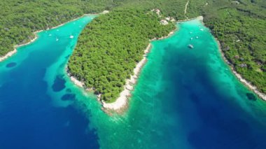 Hırvatistan 'ın Dalmaçya bölgesinde cennet gibi turkuaz deniz suyu koyları olan Rab Adası' nın hava manzaralı güzel sahili. Paradisiacal körfezlere demirlemiş yelkenliler ve vahşi plajlar. Üst görüntü görüntülerini uçur