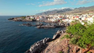 İspanya 'nın Kanarya Adaları, Tenerife' deki resimli Alcala köyünün havadan görünüşü. Geleneksel Kanarya kıyı kasabası, yeşil muz çiftlikleri ve arka planda ünlü Los Gigantes dağları
