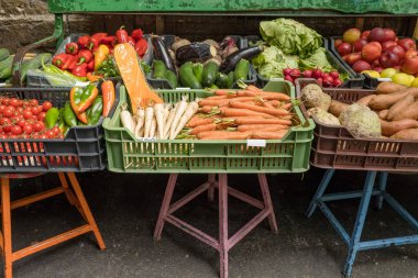 Çiftçi tezgahında çeşitli organik sebzeler var. Satılık havuç, kabak, domates, biber ve diğer sebzeler.