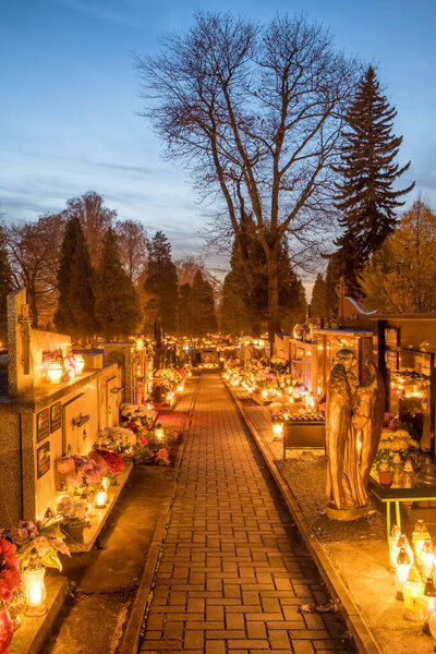 Tarnow, Poland - November 1, 2022: Candle lights on graves and tombstones at a cemetery in Poland during All Saints Day, Zaduszki day, and Day of the Dead. 