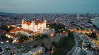 Bratislava şehri Alacakaranlık, Slovakya. Bratislava Kalesi 'nin gece havadan görünüşü. Bratislavsky Hrad, Slovakya 'nın başkenti Tuna Nehri üzerindeki tepede..
