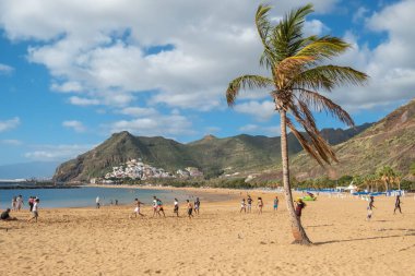 Tenerife, İspanya - 24 Ocak 2023: Tenerife, Kanarya Adaları 'ndaki San Andres tatil köyü yakınlarındaki güzel Las Teresitas plajında kimliği belirsiz gençler.