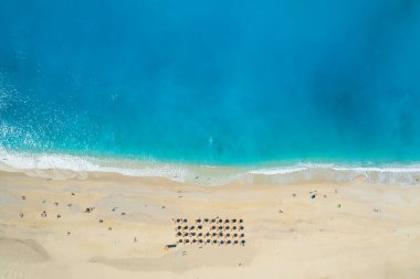 Yunanistan 'ın İyon Denizi' ndeki Kefalonia Adası 'nda güneşli bir yaz gününde güzel Myrtos plajı. Güzel bir turkuaz denizin kıyısındaki Idyllic beyaz kumlu plajı. 