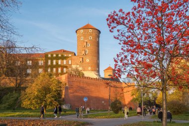 Krakow, Polonya - 27 Ekim 2022: Polonya 'nın Malopolska bölgesinde gün batımında Krakow' daki Kraliyet Wawel Şatosu. Wawel Şatosu sonbahar mevsiminde Krakow 'daki Vistula Nehri kıyısında..