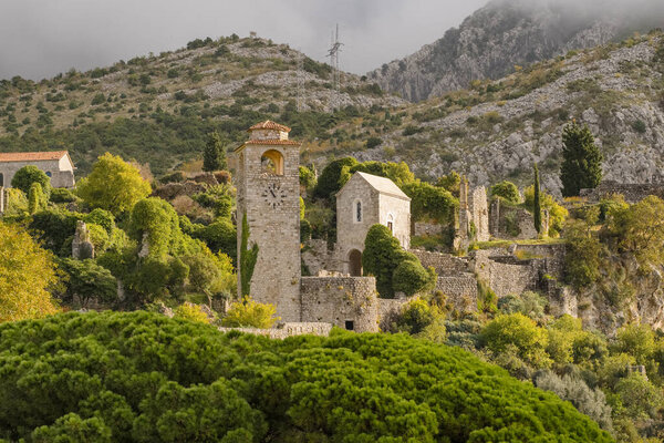 Fortress of the Old Town of Stari Bar, Montenegro. Still shot of the ruins of citadel in Stari Bar town near Bar city, Montenegro. Historic clock tower and Montenegro flag over old fortress ruins