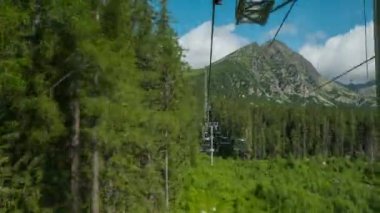 Slovakya 'daki Strbske Pleso Gölü yakınlarındaki High Tatras Ulusal Parkı' nda teleferik yolculuğunun hızlandırılması. Yazın dağlara doğru yükselen teleferiğin güzel manzarası.