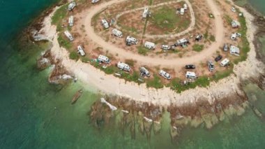 Hırvatistan 'ın Istria bölgesinin Pula kenti yakınlarındaki Adriyatik Denizi kayalık sahilinde park halindeki karavanları olan kamp alanının hava manzarası. Aile tatili karavanı, karavan tatili, karavan tatili..