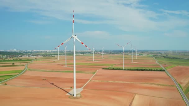 大的白色风力涡轮机在地面上旋转叶片的空中视图 向后无人娃娃射击 农场上的风车 替代能源的概念 — 图库视频影像