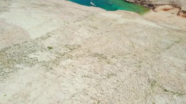Hırvatistan 'ın Dalmaçya bölgesindeki Rab adasındaki Mag plajı. Mag plajının havadan görüntüsü. Terkedilmiş deniz suyuyla çevrili muhteşem bir sahil. İHA görüntüleri gösteriliyor