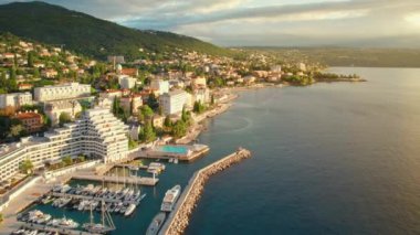 Hırvatistan 'ın Adriyatik Denizi' nin Opatija kentindeki güzel deniz manzarası. Opatija tatil köyü ve Lungomare deniz yolu hava yolu manzarası, Hırvatistan 'ın Kvarner körfezi gün doğumunda. Lüks seyahat hedefi