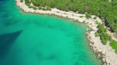 Hırvatistan 'ın Dalmaçya bölgesindeki turkuaz deniz suyuyla çarpıcı Adriyatik kıyılarının hava manzarası. Küçük bir tekne güzel bir deniz koyuna demirlemiş. Seyahat tatili kavramı