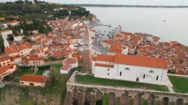 Piran 'ın St. Georges Parish Kilisesi, Tartini plaza meydanı ve Slovenya' nın tarihi binaları olan eski kentinin havadan görünüşü. Slovenya 'nın Akdeniz kıyısındaki Piran kenti